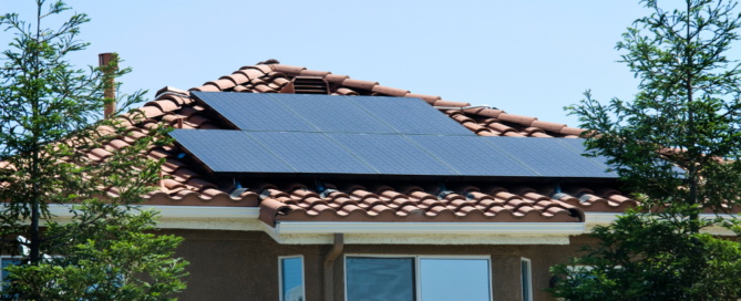 Photo of solar panels installed on a tile rooftop during a sunny day