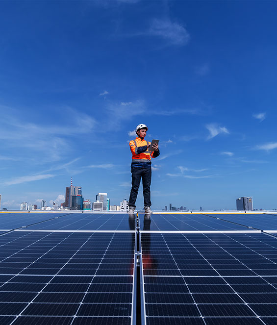 A solar installer is standing on a roof surrounded by solar panels.